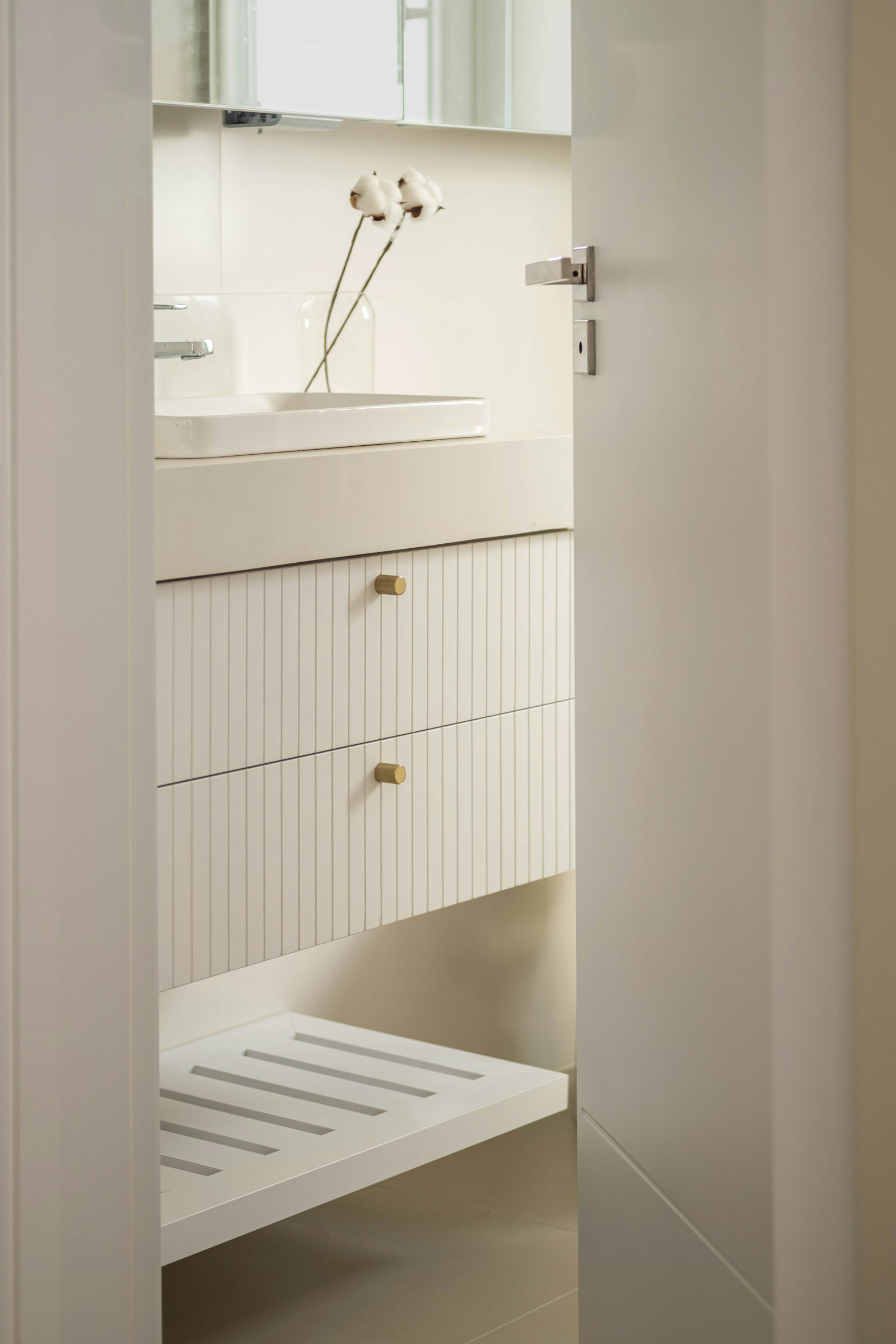 Mueble de baño blanco minimalista con espacio libre debajo